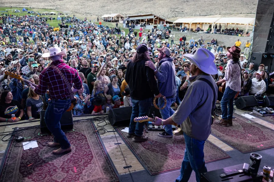Festival crowd in front of an outdoor stage at dusk